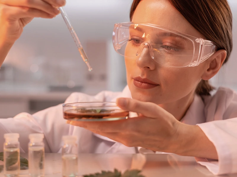 Técnica manipulando insumos para fabricação de cosméticos